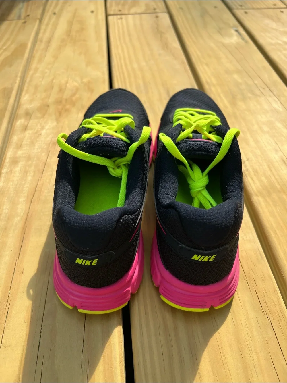 Nike Women’s navy Sneakers with Hot Pink & Neon Yellow Accents.Nike Revolution 2